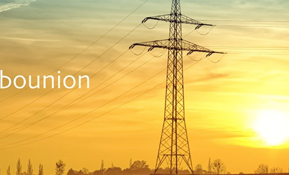 Elektrické vedení při západu slunce s logem Carbonunion v levé části obrázku