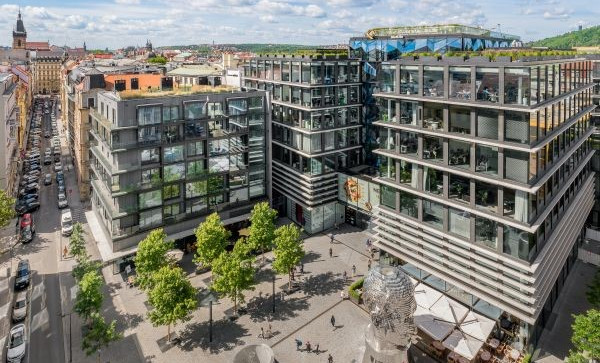 Moderní kancelářský komplex Quadrio v Praze s náměstím, stromy a pohledem na okolní město